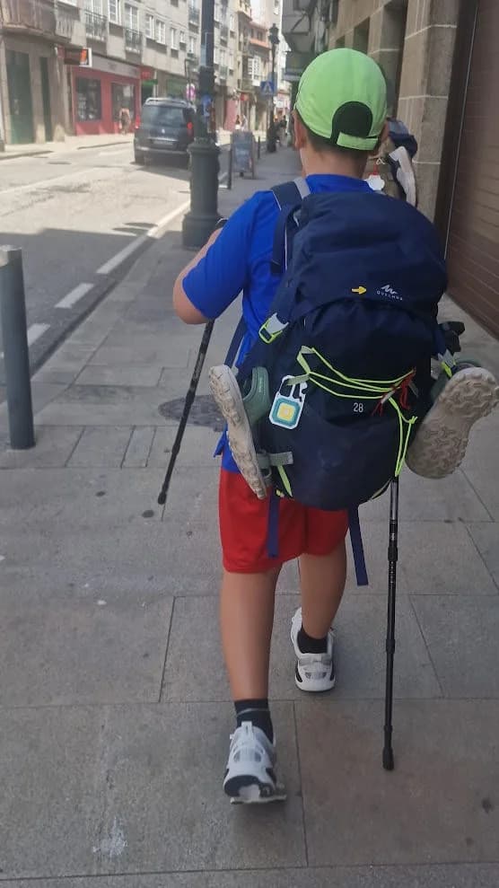 Un bambino con zaino e bastoncini